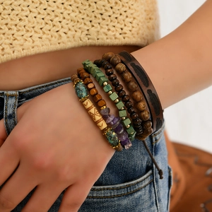 Detail of layered bohemian bracelets with turquoise beads and feather leather strap