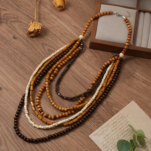 Détail d'un collier bohème multicouche en perles de bois avec fermoir mousqueton en métal