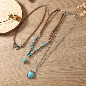 Bohemian turquoise kettingset met zilveren maan en hart hangers op hout