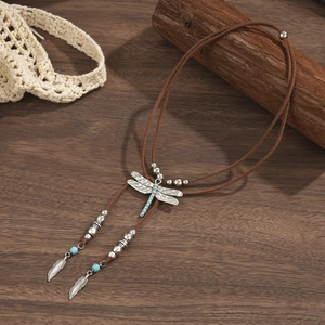 Detail of bohemian dragonfly pendant necklace with turquoise beads and feather tassels