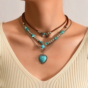 Detail van Boheemse gelaagde ketting met halve maan en hartvormige turquoise hanger