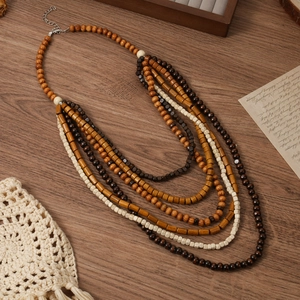 Détail d'un collier bohème multicouche en perles de bois avec fermoir argenté sur fond vintage