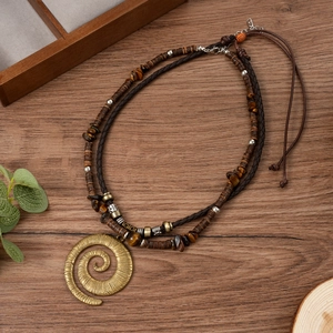 Détail du pendentif spirale vintage avec perles oeil de tigre sur collier double rang