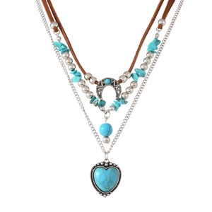 Detail van gelaagde bohemian turquoise ketting met hart- en maanhangers