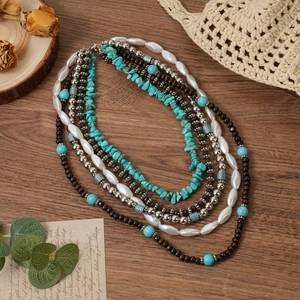 Détail d'un collier bohème multicouche avec perles turquoise et éléments en bois foncé