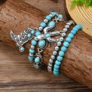 Bohemian stackable turquoise bead bracelet set with cactus and cowboy boot charms on wood
