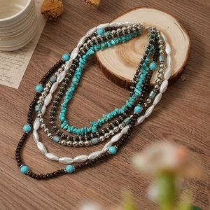 Détail d'un collier bohème 5 couches avec turquoise, perles de bois et perles