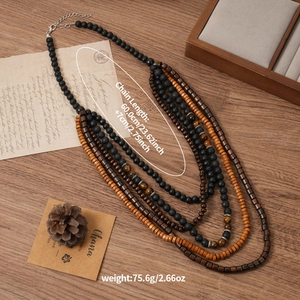 Détail d'un collier multicouche avec perles en bois, pierre de lave et perles œil de tigre