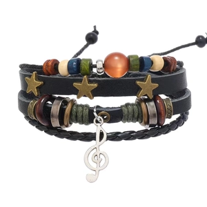 Detail of multi-layer leather bracelet with star charms and silver musical note pendant