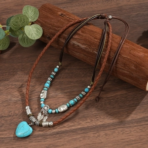 Close-up of bohemian double-layered necklace with turquoise beads and heart pendant