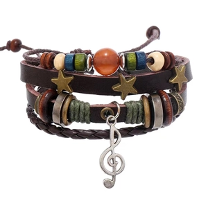 Detail of vintage multilayer leather bracelet with musical note and bronze star charms