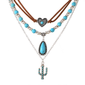 Detail van gelaagde bohemian ketting met turquoise hart-, druppel- en cactusbedels
