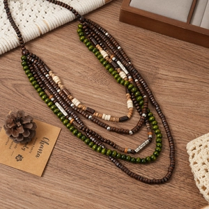 Détail d'un long collier multicouche bohème avec perles en bois et accents métalliques