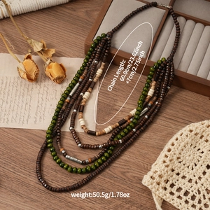Détail d'un collier bohème multicouche en perles de bois sur un fond en bois vintage