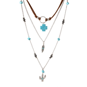 Detail van gelaagde boheemse ketting met turquoise kralen en zilveren cactus bedels