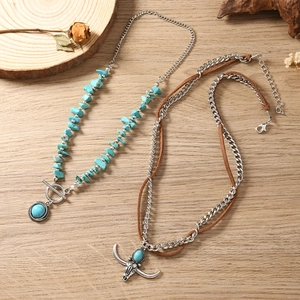 Detail van een bohemian turkoois ketting set met vintage stierenkop hanger op hout