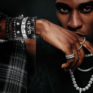 Detail of punk multilayer leather bracelet set with studs, chains and skull charm
