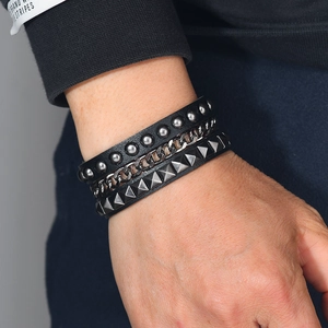 Three-piece punk leather bracelet set with studs and chains shown on a model wrist