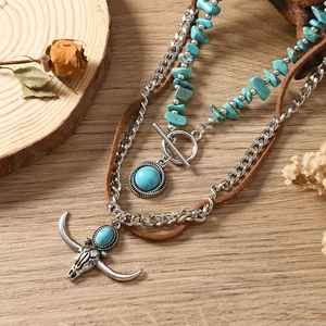 Detail van boheemse halsketting met stierenschedel-hanger en turquoise kralen
