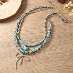 Boheemse meerlaagse ketting met turquoise kralen en zilveren strikhanger