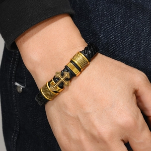 Mens vintage woven leather bracelet featuring a gold relief cross and metal accents