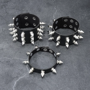 Set of 3 punk rock leather bracelets with silver cone studs on a dark stone background