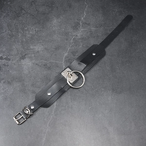 Punk leather choker with large metal O-ring and adjustable buckle on stone background