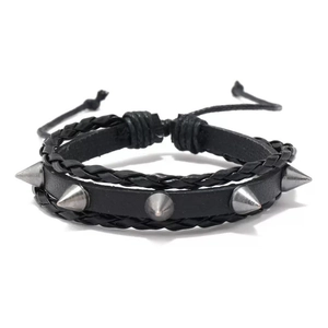 Detail of punk rivet bracelet with black leather braid and silver cone studs