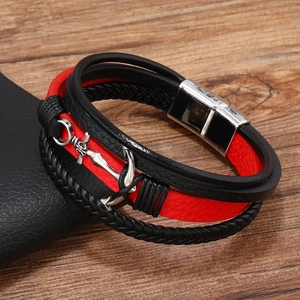 Close-up of anchor pendant and silver magnetic clasp on a layered leather bracelet