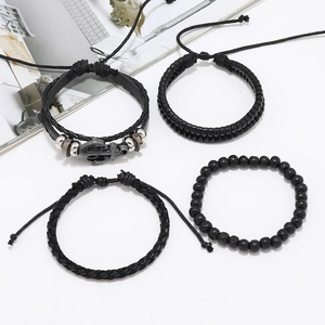 Détail d'un ensemble de quatre bracelets en cuir noir pour homme avec pendentif ancre