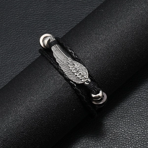 Adjustable black braided leather bracelet featuring a vintage silver alloy wing charm