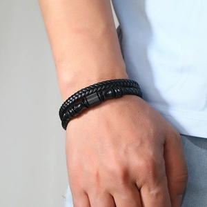 Détail du bracelet en cuir tressé noir multicouche avec fermoir en métal noir mat