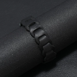 Dettaglio macro di cinturino in pelle nera intrecciata con trama a maglia di catena