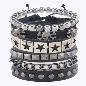 Detail von mehrlagigen Punk-Lederarmbändern mit Totenkopf, Sternanhängern und Metallnieten