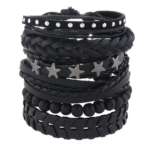 Detail von mehrlagigen Lederarmbändern mit schwarzen Holzperlen und silbernen Sternnieten