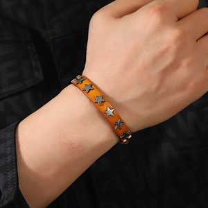 Detail of punk leather bracelet featuring orange brown texture and star alloy rivets
