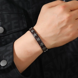 Close-up of punk style dark brown leather bracelet with five-pointed star rivets on wrist