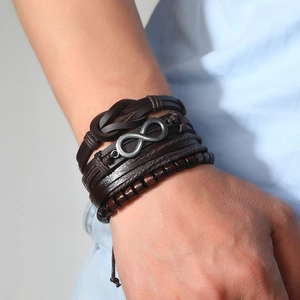 Macro detail of men's leather bracelet with infinity charm and wooden beads