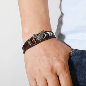 Detail of multilayer braided leather bracelet for men featuring a vintage eagle charm