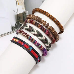 Detail of bohemian handmade stacked bracelets with wooden beads and woven fabric textures