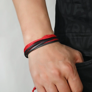Multilayer woven bracelet in red and black colors worn on wrist for casual style