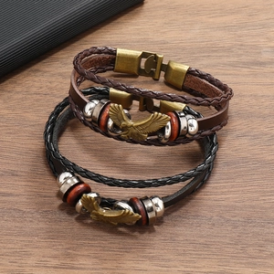 Detail of three-piece men's leather bracelet set with eagle charm and bronze metal clasp