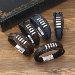 Détails de bracelets en cuir tressé avec des fermoirs magnétiques argentés sur bois rustique