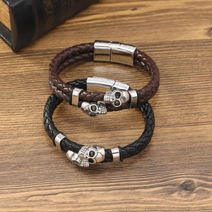 Bracelet punk en cuir pour homme avec breloques crâne argentées sur surface en bois