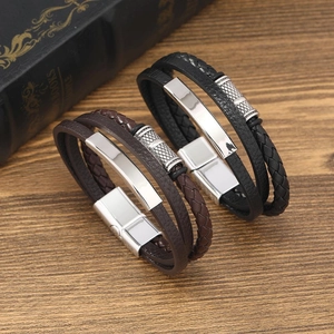Close-up of multi-layer leather bracelets with magnetic clasps on a vintage wooden desk