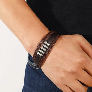 Détail d'un bracelet multicouche en cuir tressé marron pour homme avec ornements argentés