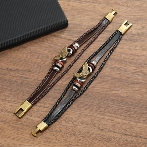 Detailed close-up of multilayer braided leather bracelet with eagle charm and metal clasp