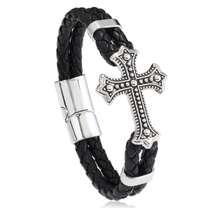 Detailed macro of men's leather braided bracelet with vintage cross pendant and clasp