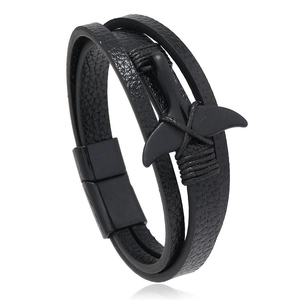 Macro detail of multi-layer black leather bracelet with matte black whale tail charm