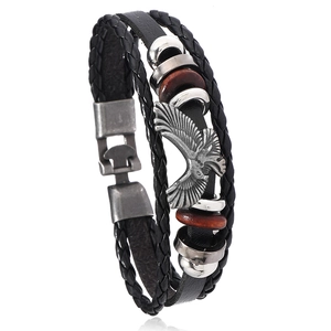 Punk leather bracelet with eagle charm and vintage beads on white background